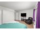 Spacious bedroom featuring a comfy bed, large closet, and a modern entertainment setup with TV and recliner at 6940 E Girard Ave # 210, Denver, CO 80224