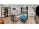 Bright living room features a sliding glass door with balcony access, modern furniture, and a stylish bookshelf at 6940 E Girard Ave # 210, Denver, CO 80224