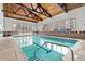 Indoor swimming pool featuring a vaulted wood ceiling and large windows with a view at 6940 E Girard Ave # 210, Denver, CO 80224