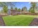Well-manicured backyard with a lush lawn and a deck, complemented by mature trees at 1238 Rosemary St, Denver, CO 80220