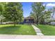 Charming single-story home with a well-manicured lawn and mature trees enhancing its curb appeal at 1238 Rosemary St, Denver, CO 80220