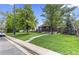 Inviting single-story home with lush green lawn, mature trees, and a welcoming front porch at 1238 Rosemary St, Denver, CO 80220