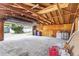 Spacious garage with exposed wood beams and an open door, offering ample storage and potential workspace at 1238 Rosemary St, Denver, CO 80220
