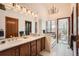 Bright bathroom featuring double sinks, a soaking tub, and a chandelier at 1408 W Briarwood Ave, Littleton, CO 80120