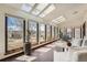 Bright sunroom with tiled floor, skylights, and large windows overlooking backyard at 1408 W Briarwood Ave, Littleton, CO 80120