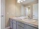 This bathroom features a double sink vanity, neutral paint, decorative mirrors, and tile flooring at 10914 W Coco Pl, Littleton, CO 80127