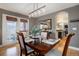 Dining room with hardwood floors, modern light fixture, and an open doorway to the kitchen at 10914 W Coco Pl, Littleton, CO 80127