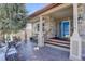 Charming stone front porch featuring a bright blue door, wooden steps, and seating area perfect for relaxing outdoors at 10914 W Coco Pl, Littleton, CO 80127