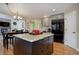 Bright kitchen features a granite island, hardwood floors, black refrigerator, and gray cabinets at 10914 W Coco Pl, Littleton, CO 80127