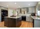 Kitchen with a black refrigerator and oven, a granite island, and grey cabinets at 10914 W Coco Pl, Littleton, CO 80127