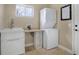 Functional laundry room with a utility sink, storage shelves, and a washer/dryer combo at 10914 W Coco Pl, Littleton, CO 80127