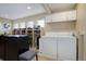 A large, well-lit laundry room with shelving and a closet system for clothing and storage, along with a washer and dryer at 10914 W Coco Pl, Littleton, CO 80127