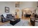 Open concept living room with hardwood floors, comfortable seating, and seamless transition to the kitchen area at 10914 W Coco Pl, Littleton, CO 80127