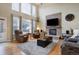 Open concept living room with a stone fireplace and lots of natural light from large windows at 10914 W Coco Pl, Littleton, CO 80127