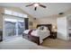 Bright main bedroom features a ceiling fan, carpet, large windows and a private balcony at 10914 W Coco Pl, Littleton, CO 80127