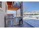 Outdoor kitchen featuring a built-in grill, counter space, and seating with a stone pillar accent at 10914 W Coco Pl, Littleton, CO 80127