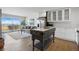 Open living space with a balcony, hardwood floors, stainless steel appliances, and an antique kitchen island at 700 N Washington St # 1104, Denver, CO 80203
