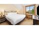 Bright bedroom with a comfortable bed, a wooden desk and a large window offering natural light and views at 50 Mountain Thunder Dr # 1402, Breckenridge, CO 80424