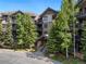 Building exterior with stone and wood accents, balconies, and lush trees surrounding at 50 Mountain Thunder Dr # 1402, Breckenridge, CO 80424