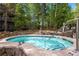 A blue tiled hot tub surrounded by stone with metal handrail surrounded by trees at 50 Mountain Thunder Dr # 1402, Breckenridge, CO 80424