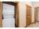 Laundry room with stacked washer and dryer, with wooden trim and doors at 50 Mountain Thunder Dr # 1402, Breckenridge, CO 80424