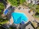 Aerial view of pool area with large pool, hot tub, lounge chairs, and trees at 50 Mountain Thunder Dr # 1402, Breckenridge, CO 80424