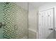 Modern bathroom featuring glass shower with unique green and white patterned tile at 4640 W Ellsworth Ave, Denver, CO 80219