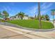 Landscaped corner lot with lush lawn, concrete border, and mature trees under a sunny blue sky at 4640 W Ellsworth Ave, Denver, CO 80219