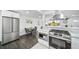 Well lit kitchen boasts stainless steel appliances and bright white cabinets, plus an eat-in area at 4640 W Ellsworth Ave, Denver, CO 80219
