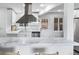 Bright kitchen boasts white cabinetry, marble countertops, stainless steel appliances, and ample natural light at 4640 W Ellsworth Ave, Denver, CO 80219