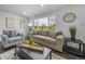 Bright living room with large windows, modern decor, plush seating, and dark hardwood floors at 4640 W Ellsworth Ave, Denver, CO 80219