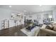 Open-concept living space featuring modern decor, a breakfast bar, and hardwood floors at 4640 W Ellsworth Ave, Denver, CO 80219