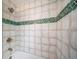 Close up of the shower with textured decorative tiles and bronze fixtures at 4640 W Ellsworth Ave, Denver, CO 80219