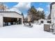 Snowy backyard with detached garage, patio furniture, and storage shed at 12029 W Dakota Dr, Lakewood, CO 80228