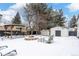 Backyard features a pergola, fire pit, and storage shed in winter setting at 12029 W Dakota Dr, Lakewood, CO 80228