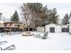 Backyard features a pergola, fire pit, and storage shed in winter setting at 12029 W Dakota Dr, Lakewood, CO 80228