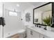 Modern bathroom with a walk-in shower, white vanity, and black accents at 12029 W Dakota Dr, Lakewood, CO 80228