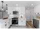 Modern kitchen with white cabinets, stainless steel appliances, and quartz countertops at 12029 W Dakota Dr, Lakewood, CO 80228