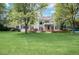 Large backyard with lush greenery, mature trees, and a patio, creating a serene outdoor space at 7 Mockingbird Ln, Cherry Hills Village, CO 80113