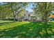 Lush backyard featuring a manicured lawn, mature trees, and brick patio with an outdoor dining area at 7 Mockingbird Ln, Cherry Hills Village, CO 80113