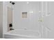 Bathtub features decorative tile, a shower head, and a built in soap dish at 7 Mockingbird Ln, Cherry Hills Village, CO 80113