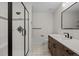 Bathroom features a glass door shower, wood cabinets, modern fixtures, and gray accent tiles at 7 Mockingbird Ln, Cherry Hills Village, CO 80113