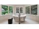 Stunning modern bathtub surrounded by bright windows providing a view of the outdoors at 7 Mockingbird Ln, Cherry Hills Village, CO 80113