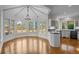 Bright breakfast nook with bay windows, hardwood floors, and elegant chandelier at 7 Mockingbird Ln, Cherry Hills Village, CO 80113