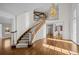 Grand foyer featuring a curved staircase, hardwood floors, and a stunning chandelier at 7 Mockingbird Ln, Cherry Hills Village, CO 80113