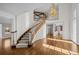 Grand foyer with a curved staircase, hardwood floors, and a striking chandelier at 7 Mockingbird Ln, Cherry Hills Village, CO 80113