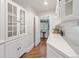 Hallway with white cabinets and hardwood floors leads to breakfast nook at 7 Mockingbird Ln, Cherry Hills Village, CO 80113