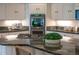 Kitchen featuring a gas cooktop on the island, white cabinets, and stainless steel appliances at 7 Mockingbird Ln, Cherry Hills Village, CO 80113