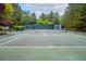 Well-maintained tennis court surrounded by lush greenery, perfect for recreational activities and sports at 7 Mockingbird Ln, Cherry Hills Village, CO 80113