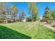Lush backyard featuring a large grassy area, mature trees, and a shed, ideal for outdoor activities at 10062 Eagle Valley Way, Highlands Ranch, CO 80129